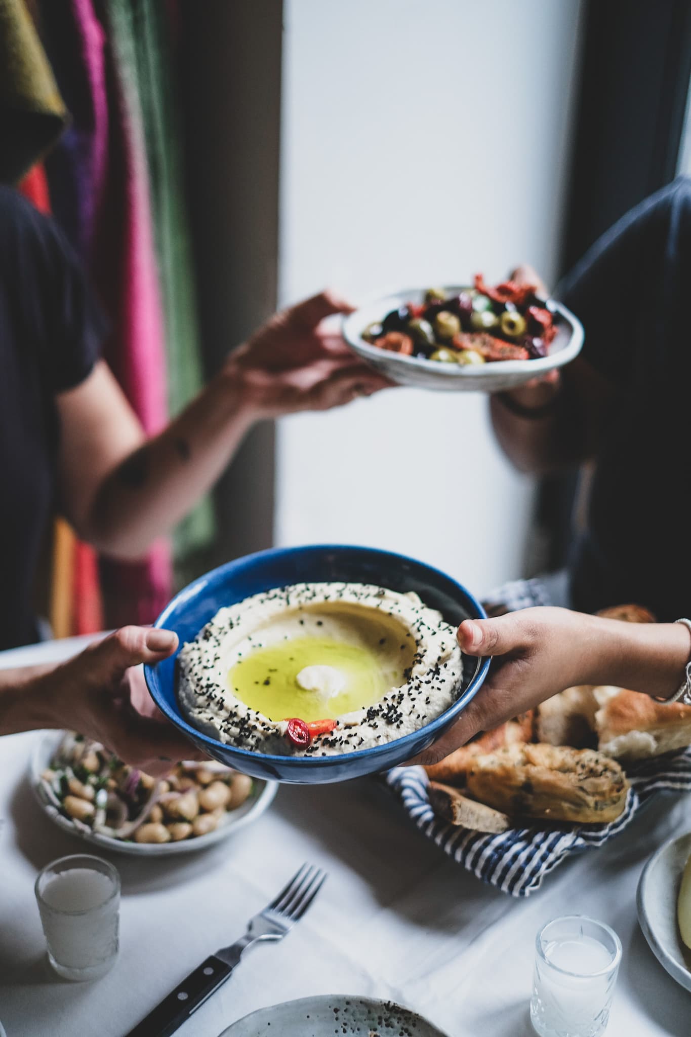 Shared dishes being passed across the table during a Factory Girl event